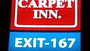 A sign with "RED CARPET INN" and "EXIT-167".