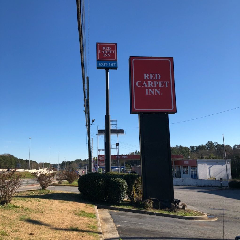A Red Carpet Inn sign with an EXIT-167 sign above it.