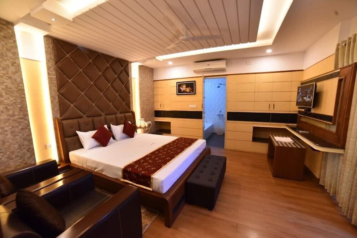 A modern hotel room with a large bed, a desk, and a television.