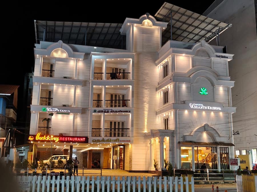 Ein mehrstöckiges Hotel mit Balkonen, einem Restaurant und einem Schild für Hotel Vashanth Krishna.