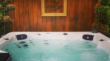 A hot tub with a wooden backdrop and a framed picture.