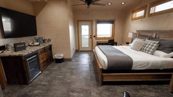Un dormitorio con cama, escritorio, televisor y ventana.