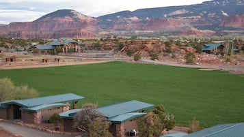 Escape to a serene retreat surrounded by rugged mountains and expansive green fields, perfect for outdoor activities.