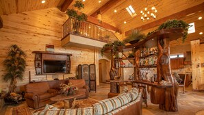 A spacious living area with a large sofa, a television, and a wooden coffee table.