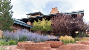 A stone building with a balcony, surrounded by lavender and other plants.