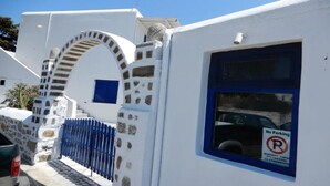 A white building with a blue door and a 'No Parking' sign. - Sourmeli Pension (Mykonos)