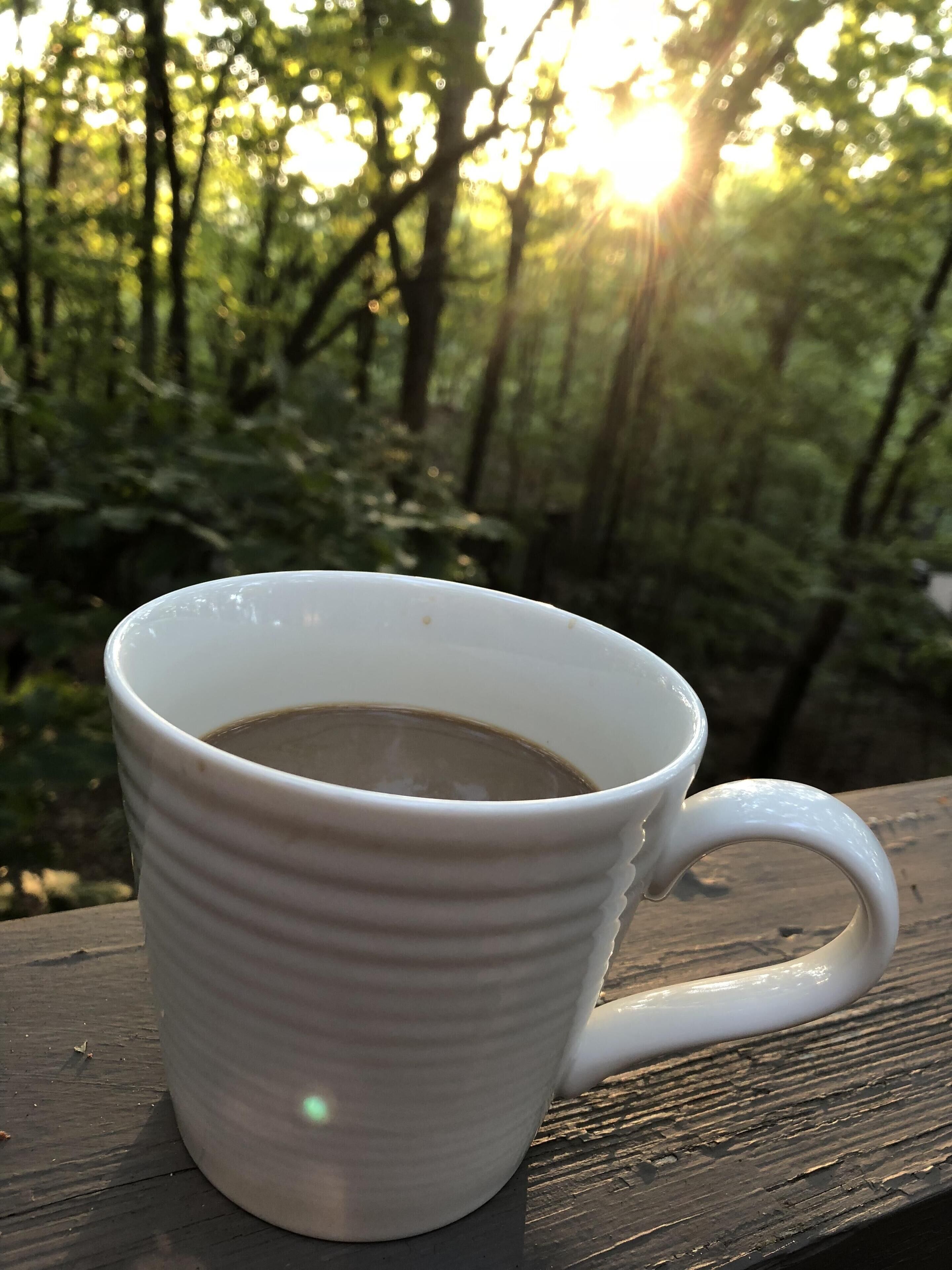 A white ceramic mug with a handle, placed on a wooden surface.
