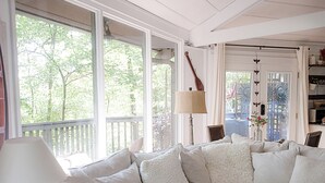 A cozy living room with a sectional sofa, a lamp, and a view of the outdoors.