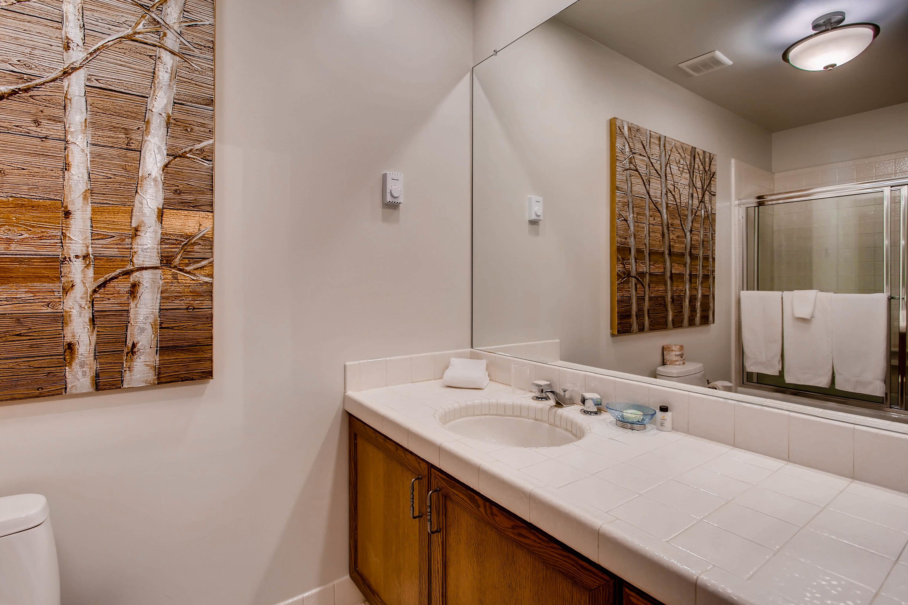 Une salle de bain avec un mur recouvert de lambris en bois, un lavabo et un miroir.