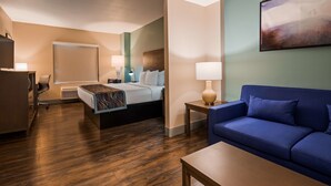 A hotel room with a bed, a blue sofa, a desk, and a chair. - Best Western Plus New Barstow Inn & Suites (Barstow)