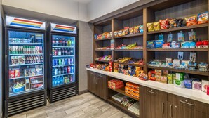 A self-service snack and beverage kiosk with refrigerated drink dispensers and shelves stocked with snacks and beverages. - Best Western Plus Rapid City Rushmore (Rapid City)