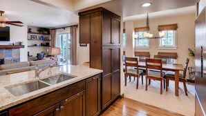 A kitchen with dark wooden cabinets, a granite countertop, and a built-in sink.