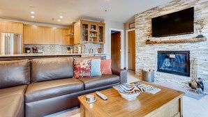 Ein modernes Wohnzimmer mit einer Ledersofa, einem Holztisch und einem Kamin.