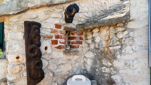 Un muro de piedra con un grabado de madera y una cuenca de piedra.