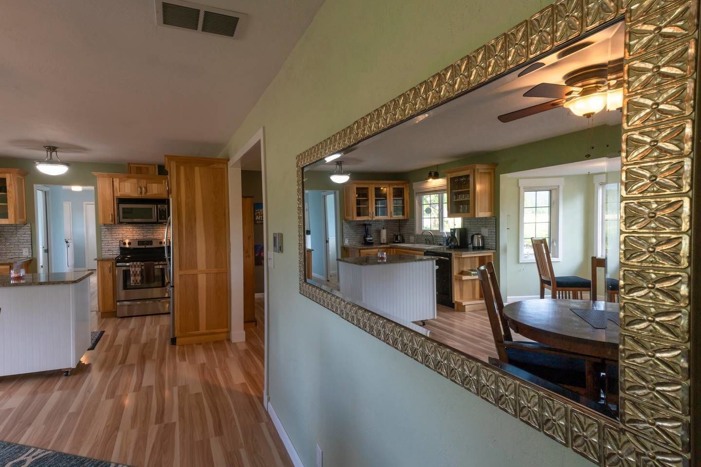 A spacious kitchen with wooden cabinets, a central island, and a dining area with a large table and chairs.