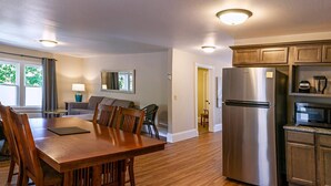 Una cocina moderna con un refrigerador de acero inoxidable, una mesa de comedor de madera y sillas.