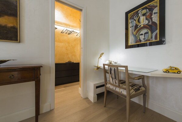 A room with a desk, chair, and artwork on the walls.