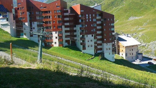 A multi-story hotel with a modern architectural design, featuring balconies and a mix of brick and white exterior walls.
