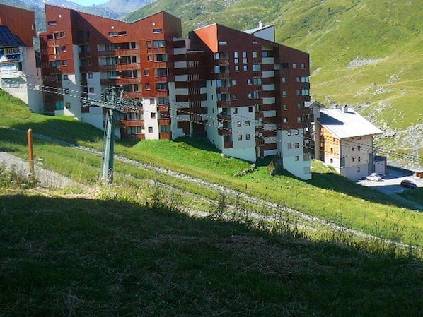 A multi-story hotel with a modern architectural design, featuring balconies and a mix of brick and white exterior walls.