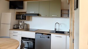 A compact kitchen with a microwave, toaster, and dishwasher.