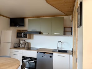 A compact kitchen with a microwave, toaster, and dishwasher.