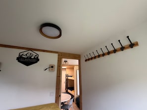 A room with a bunk bed, a round table, and a coat rack. - Apartment in Les Menuires, 4 pers, ski-in/ski-out (Les Menuires)
