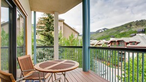A balcony with a round table and chairs, overlooking a residential area with houses and a hilly landscape. - Centennial 3 (Avon)