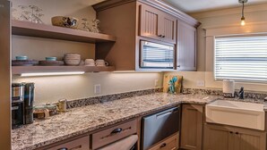 A kitchen with granite countertops, a built-in dishwasher, and wooden cabinets. - Redtail Suites ~ Entire Home ~ Sleeps 12 ~ Tesla Station (Ashland)