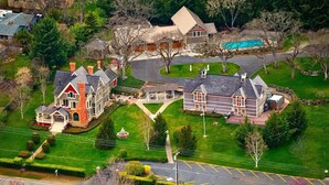 A large, multi-story house with a well-maintained lawn and a swimming pool. - Jacksonville's Historic Nunan House (Jacksonville)