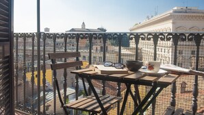 Een balkon met een tafel, stoelen en een krant.