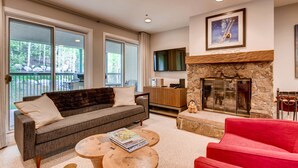 A living room with a sofa, red chair, and a fireplace.