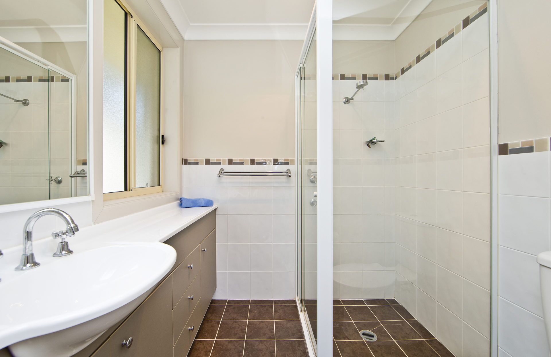 Une salle de bain avec un lavabo, un miroir et une douche.