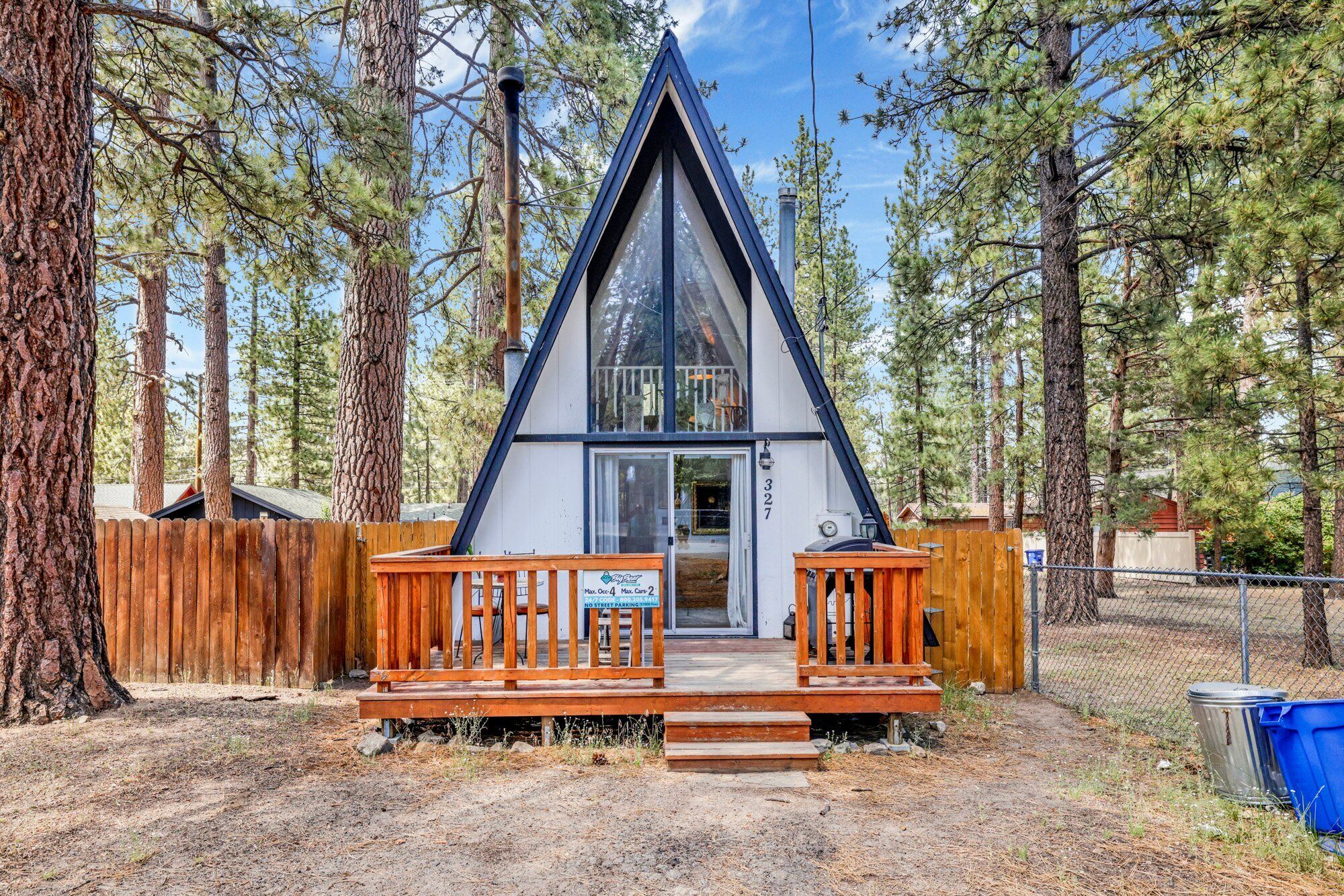 Welcoming cabin entry surrounded by towering pine trees, offering fresh mountain air and a peaceful forest setting—the perfect first impression for your Big Bear Lake getaway.