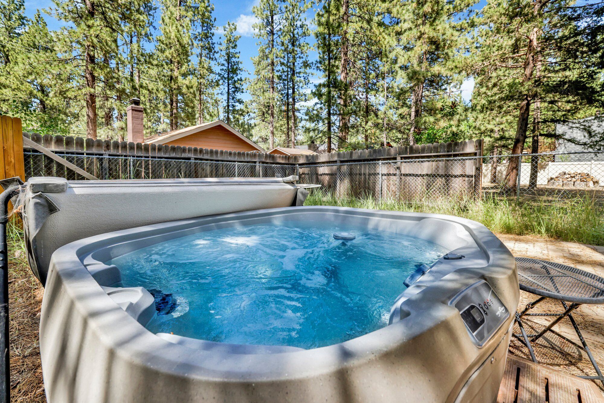 Private outdoor hot tub, surrounded by tall pines, perfect for relaxing under the trees after a day of adventure—enjoy peaceful forest views, fresh air, and a truly rejuvenating stay.