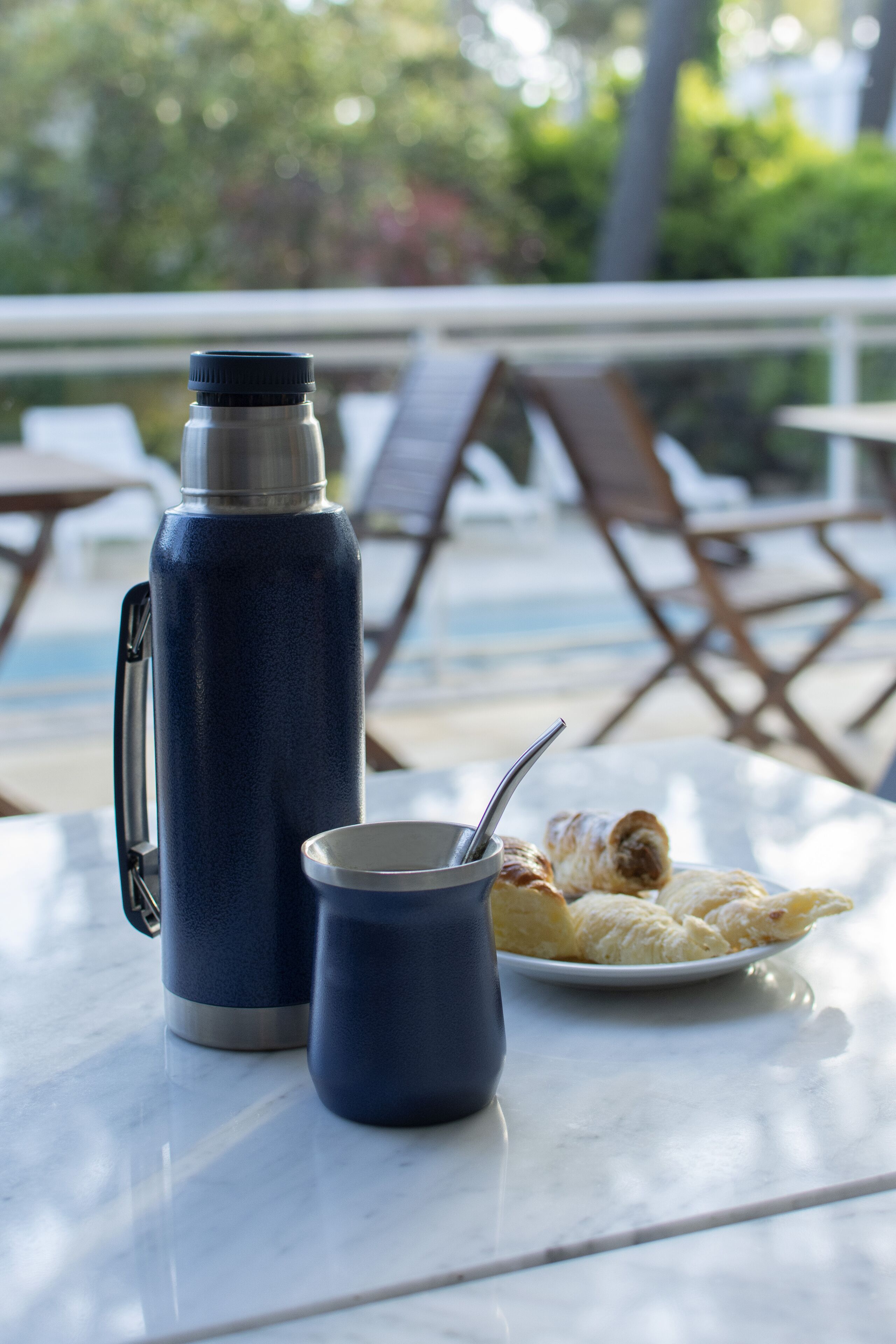 Ein Tisch mit einer Wasserflasche, einer Tasse und einem Tablett Gebäck.