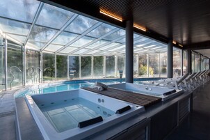 Una piscina cubierta, una piscina al aire libre de temporada, sombrillas