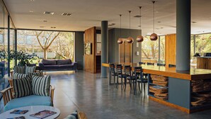 A modern interior with a dining area, sofas, and a bar. - Destinar Apart Hotel (Carilo)