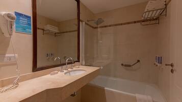 Ein Badezimmer mit Waschbecken, Spiegel und Dusche. An der Wand befinden sich ein Handtuchhalter und ein Föhn.