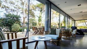 A modern interior with a round table, wooden chairs, and a sofa. - Destinar Apart Hotel (Carilo)