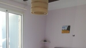 Un dormitorio con una cama, una mesita de noche, una lámpara y un cuadro en la pared.