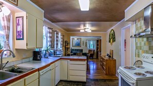A compact kitchen with a central island, a stove, and a sink.