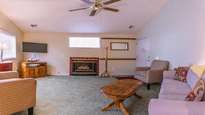 A living room with a fireplace, a ceiling fan, and a television. - Oak Hideaway Cottage- 1.5 Blocks to OSF (Ashland)