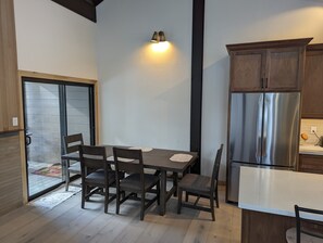 Una cucina moderna con un tavolo da pranzo, sedie e un frigorifero in acciaio inox.
