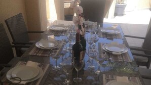 Una mesa de comedor lista para una comida, con varios platos, vasos y cubiertos.