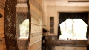 Uma cozinha rústica com paredes de madeira, uma janela grande e um relógio.