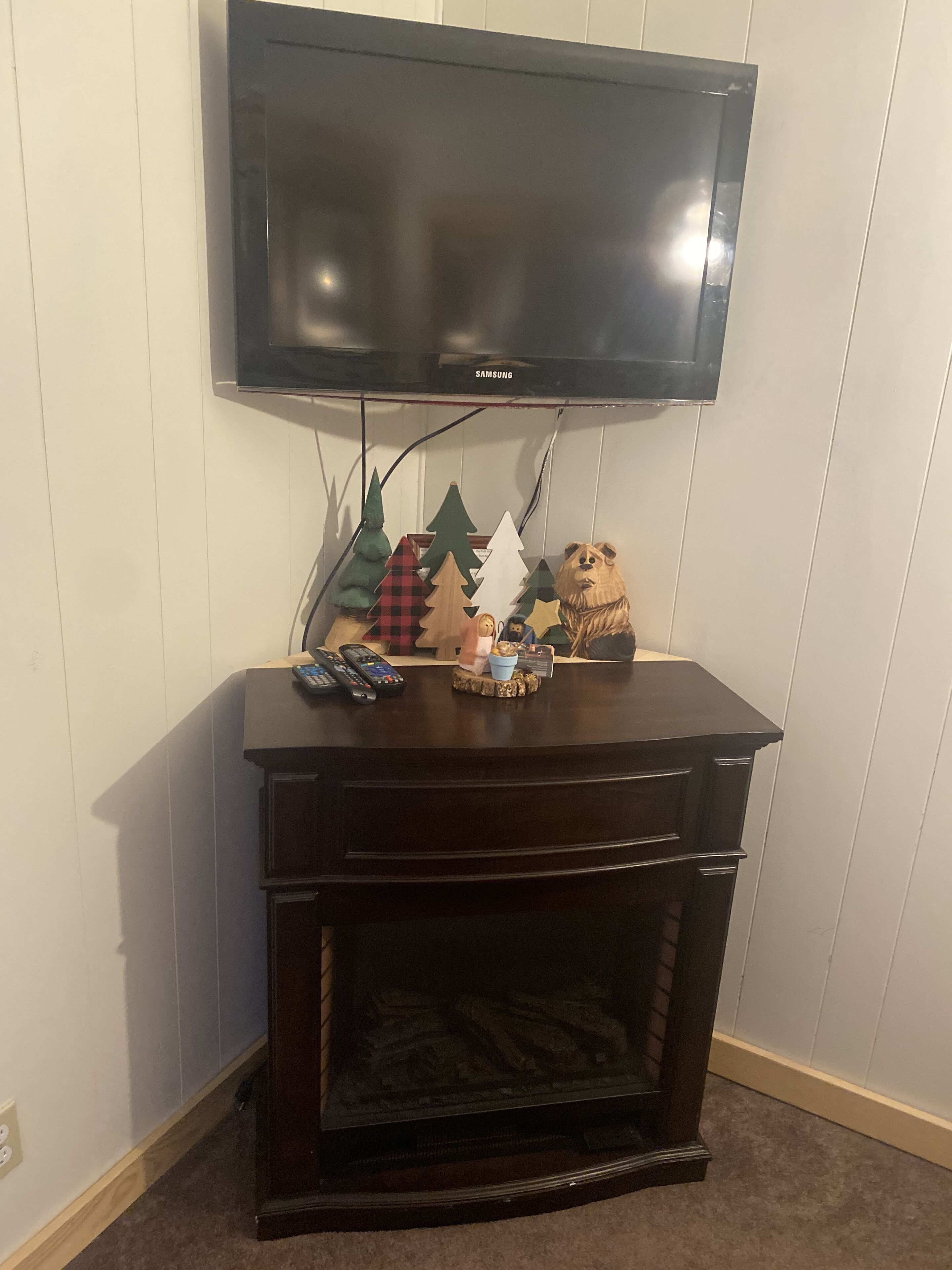 A dark wooden entertainment center with a flat-screen TV mounted above it.