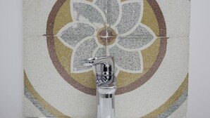 A bathroom with a modern sink and a decorative tile wall featuring a floral pattern. - Residence Ventimiglia (Gangi)