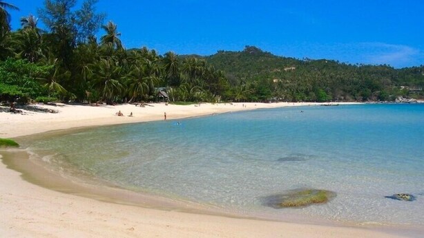 A beach with clear turquoise water, white sand, and dense tropical vegetation. - Splendid PENTHOUSE 120m² seaside, fitness room, panoramic view 4/5pers. (BO PHUT)