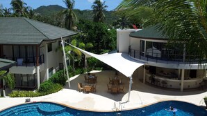 A resort with a swimming pool, outdoor seating, and a view of the surrounding greenery. - Splendid PENTHOUSE 120m² seaside, fitness room, panoramic view 4/5pers. (BO PHUT)