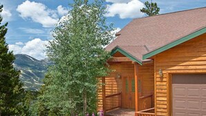 A wooden cabin with a porch, a garage, and a mountain view. - Spectacular Views, Hiking & Skiing, Spacious Cozy Luxury, Hot tub, Fireplace (Breckenridge)